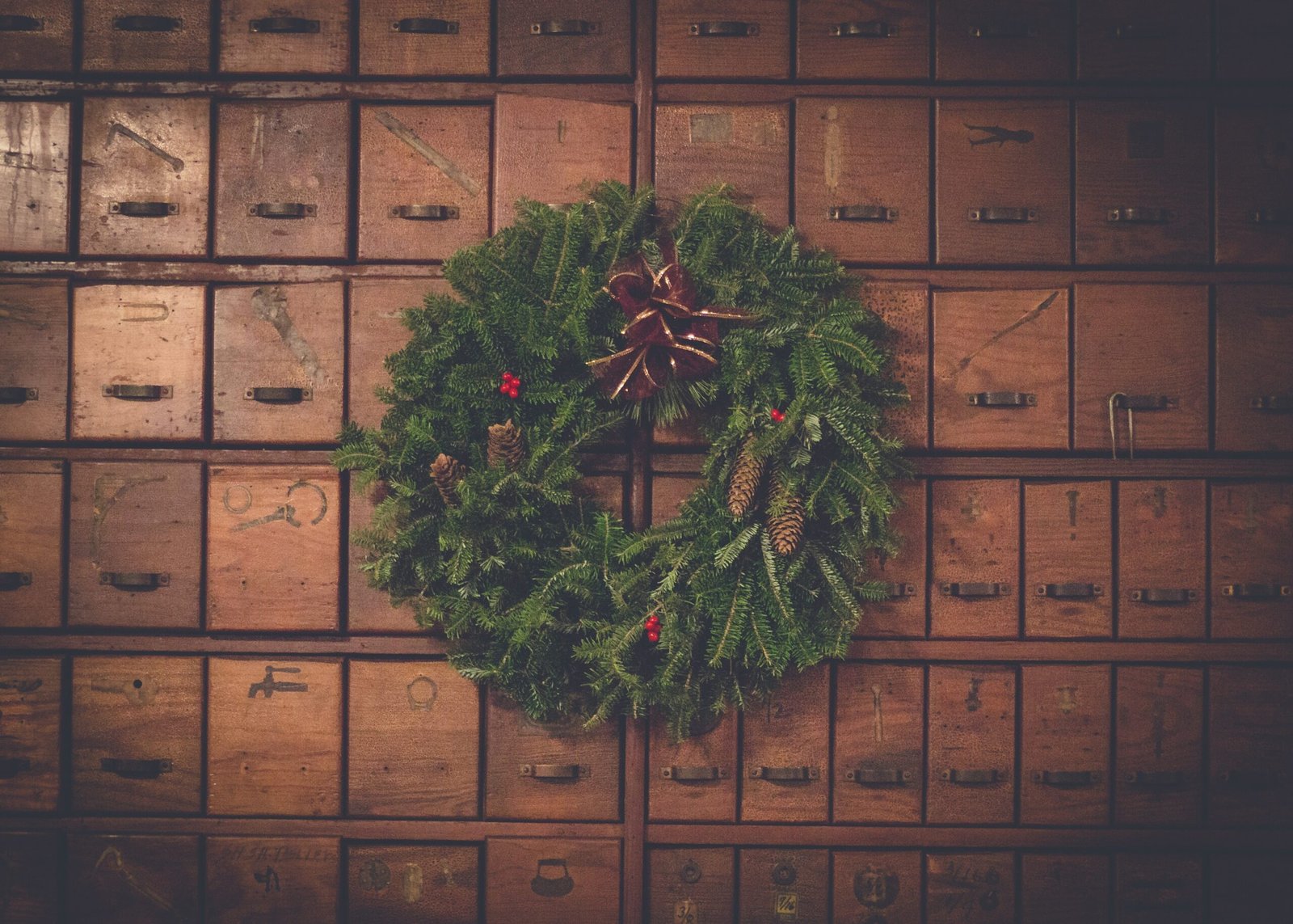 green and brown pinecone Christmas wreath on wooden drawers