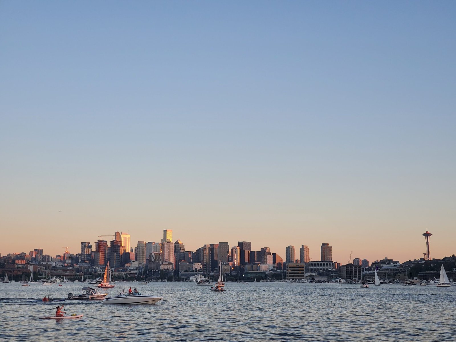 sailboats in the water with a city in the background