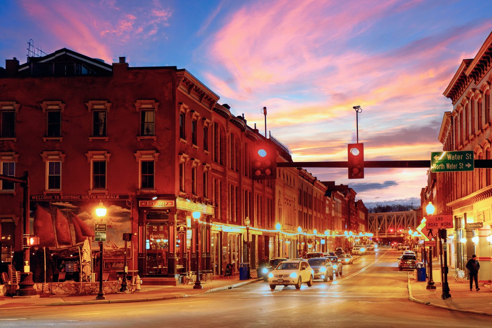 a city street at dusk with a traffic light