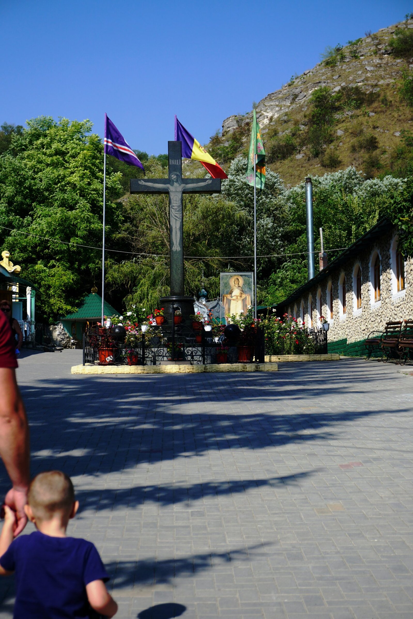 a man holding a child's hand in front of a cross