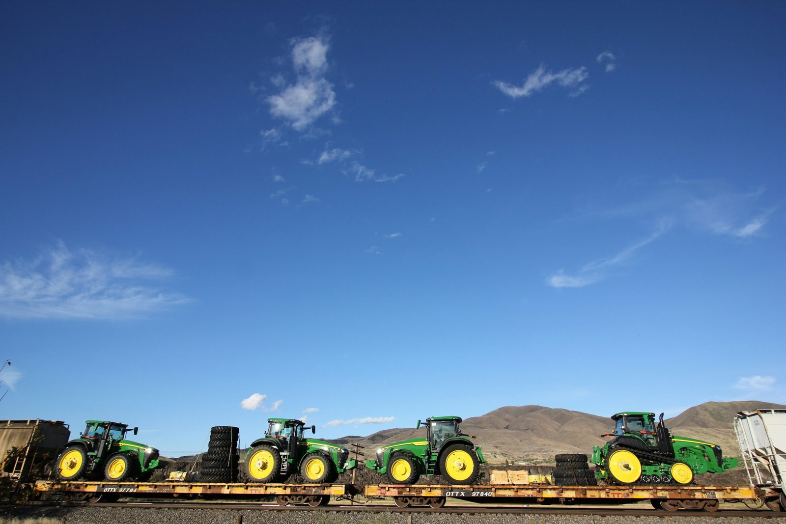 a row of tractors sitting on top of a train track