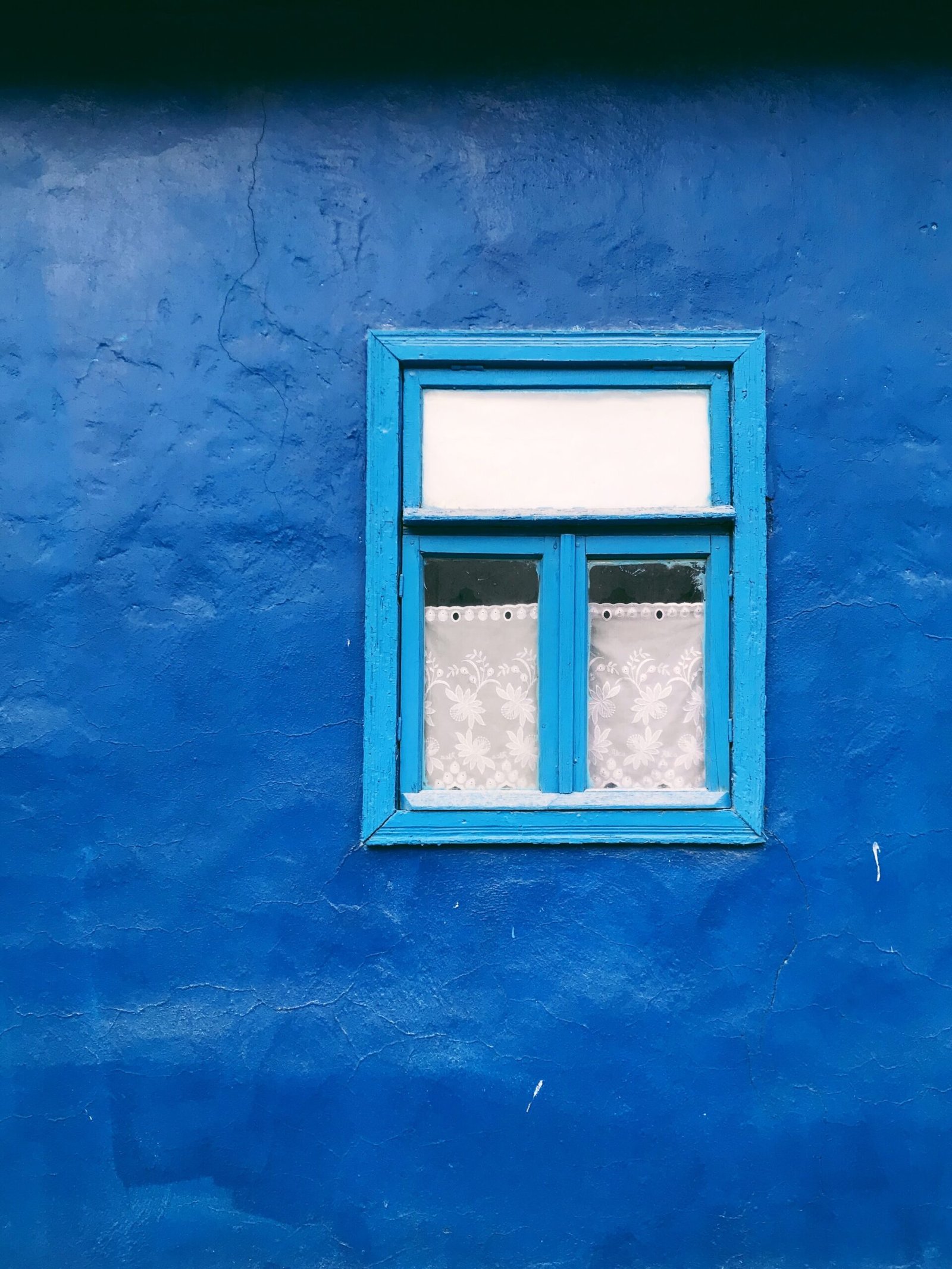 blue concrete wall with white framed window