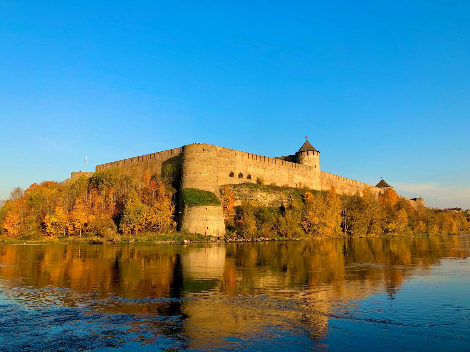 brown concrete building on top of hill by the sea under blue sky during daytime