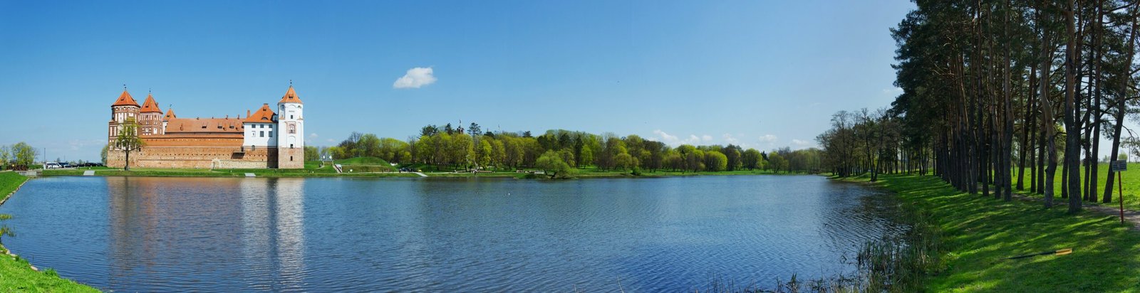 castle surrounded with trees beside body of water