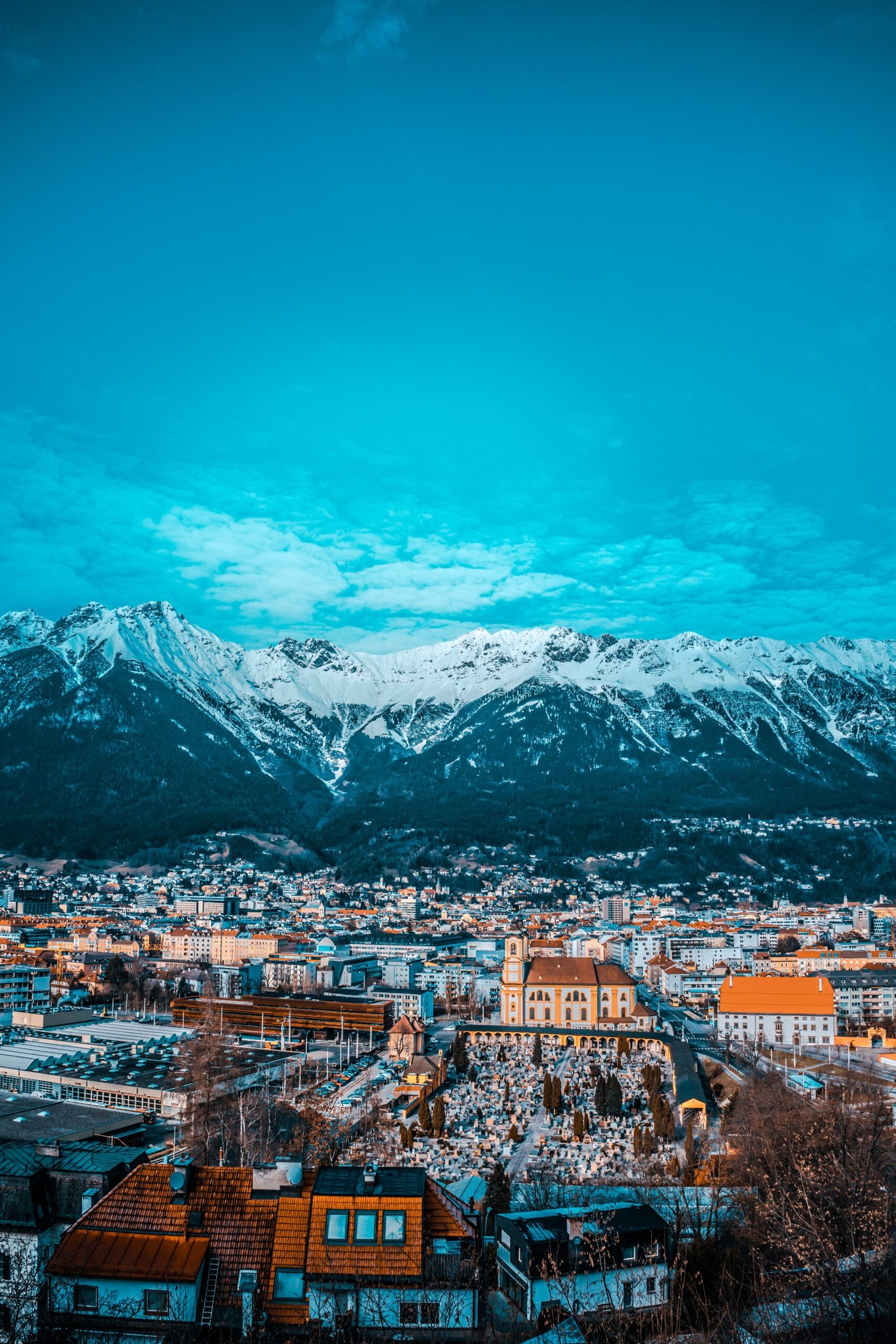 city buildings near snow covered mountain during daytime