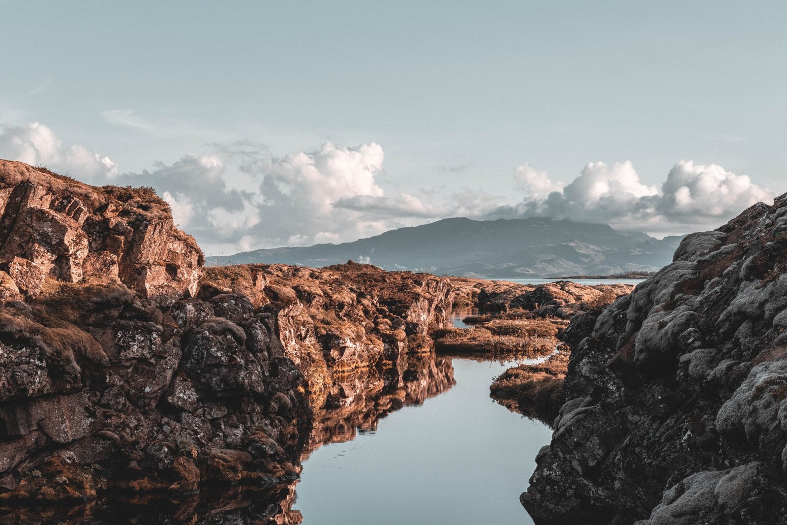 reflection of rock mountain on body of water