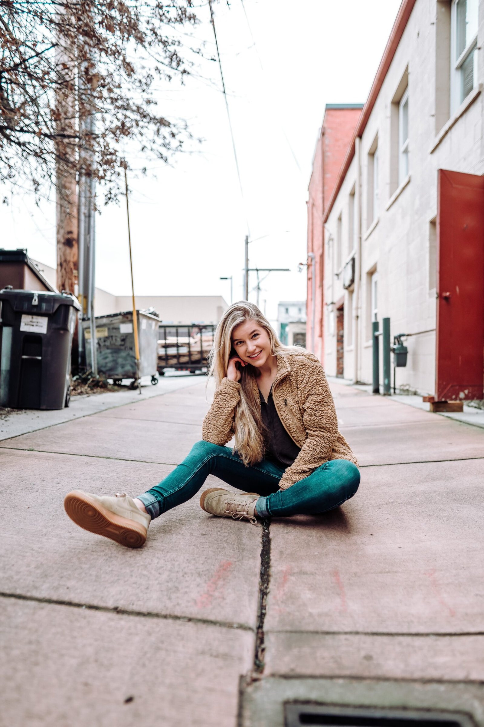 woman sitting on sidewalk